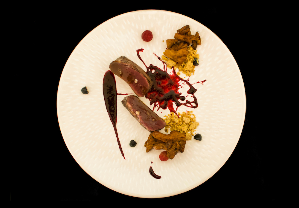 Filetto di cervo marinato con miele soia con il suo fondo e sale Maldon con gallinacci saltati in padella, salsa ai frutti rossi e pane di segale sbriciolato