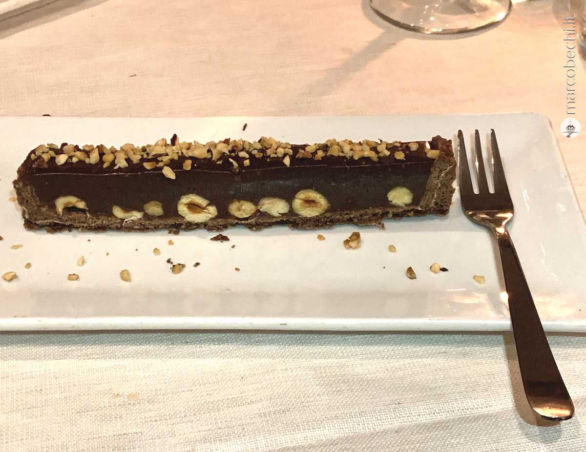 Noccioloso, base pastafrolla al cioccolato, una ganache alle nocciole e nocciole croccanti