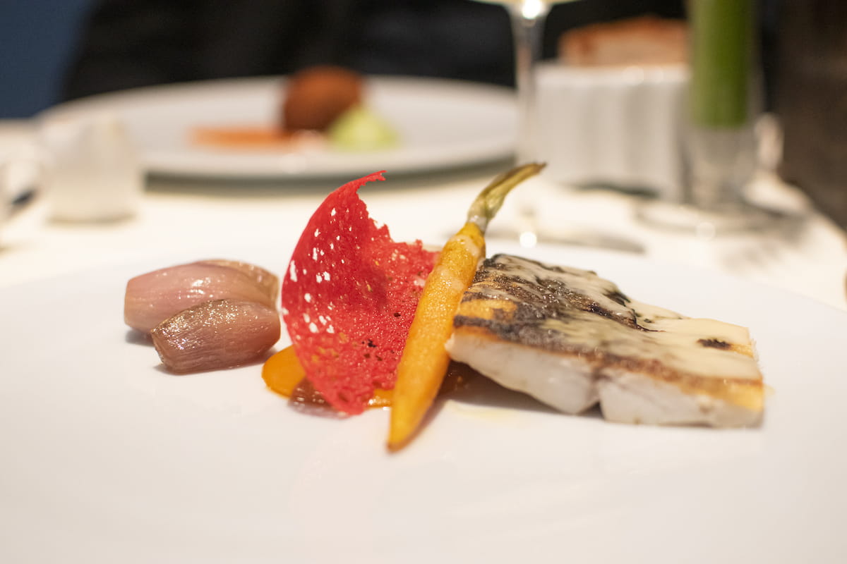Branzino, melanzane croccanti con acqua di cioccolato al miele e aceto di mele