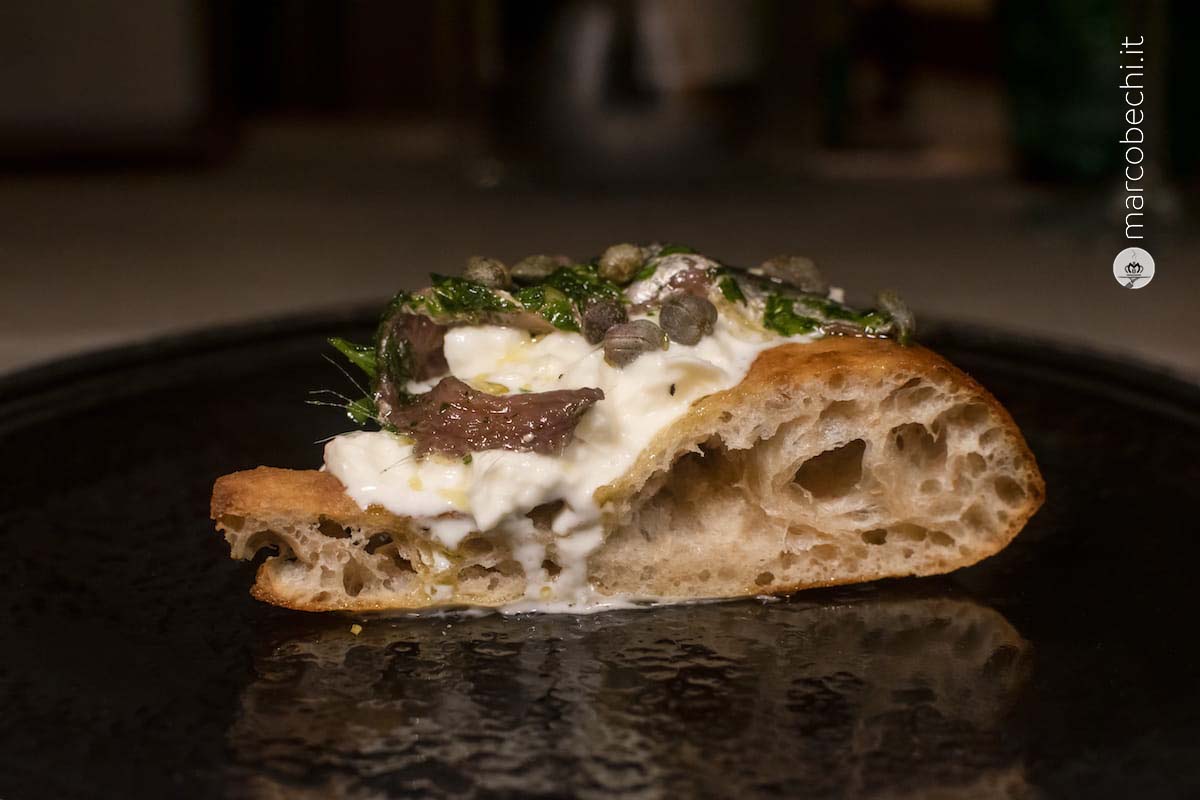 Acciughe sotto pesto del Cantabrico in olio evo del Ch. Classico, burrata pugliese e capperi di Pantelleria (il pesto è un'antica ricetta della Pergola)