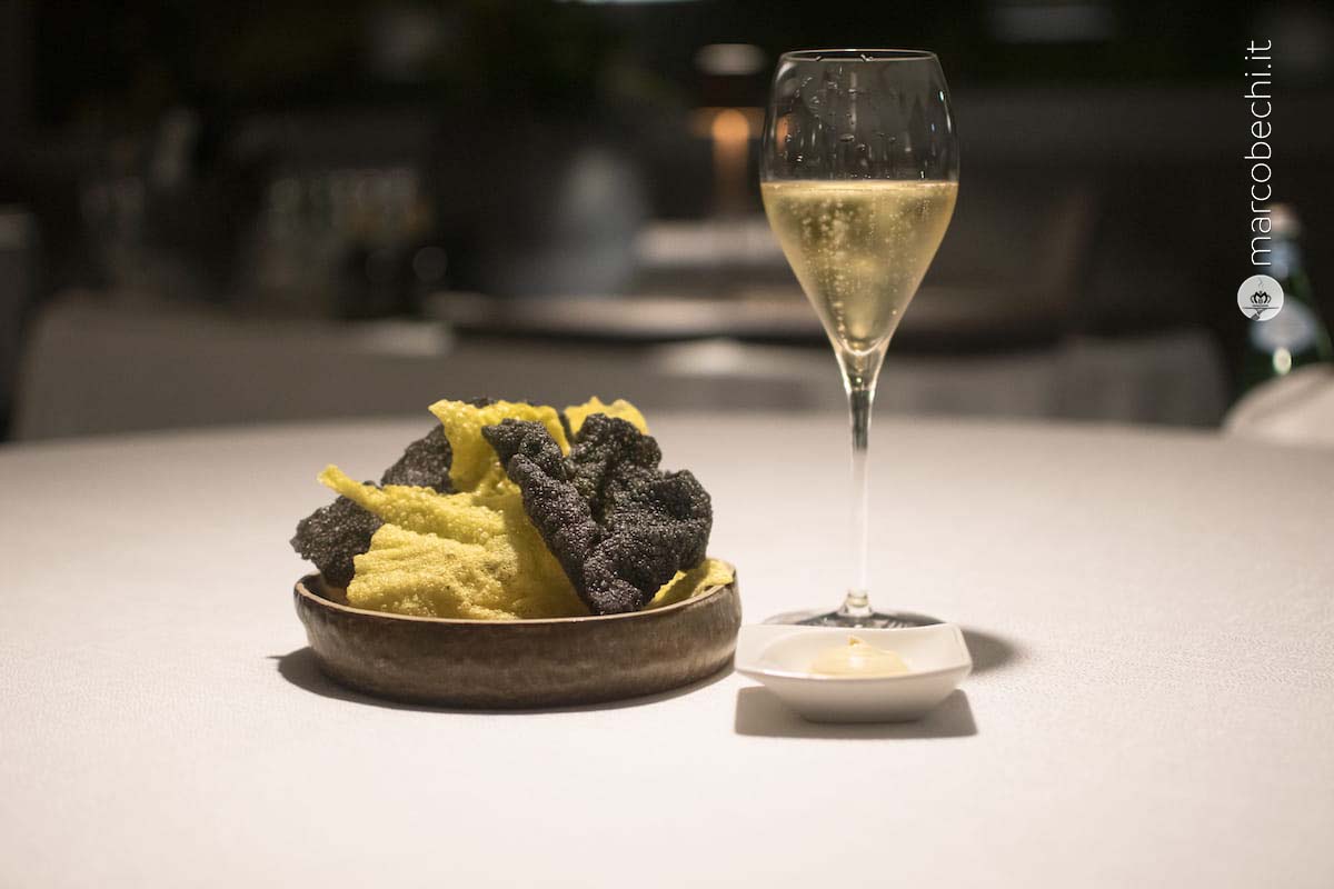 Chips vegetale a base di riso, zafferano e nero di seppia con maionese di soia e lime.