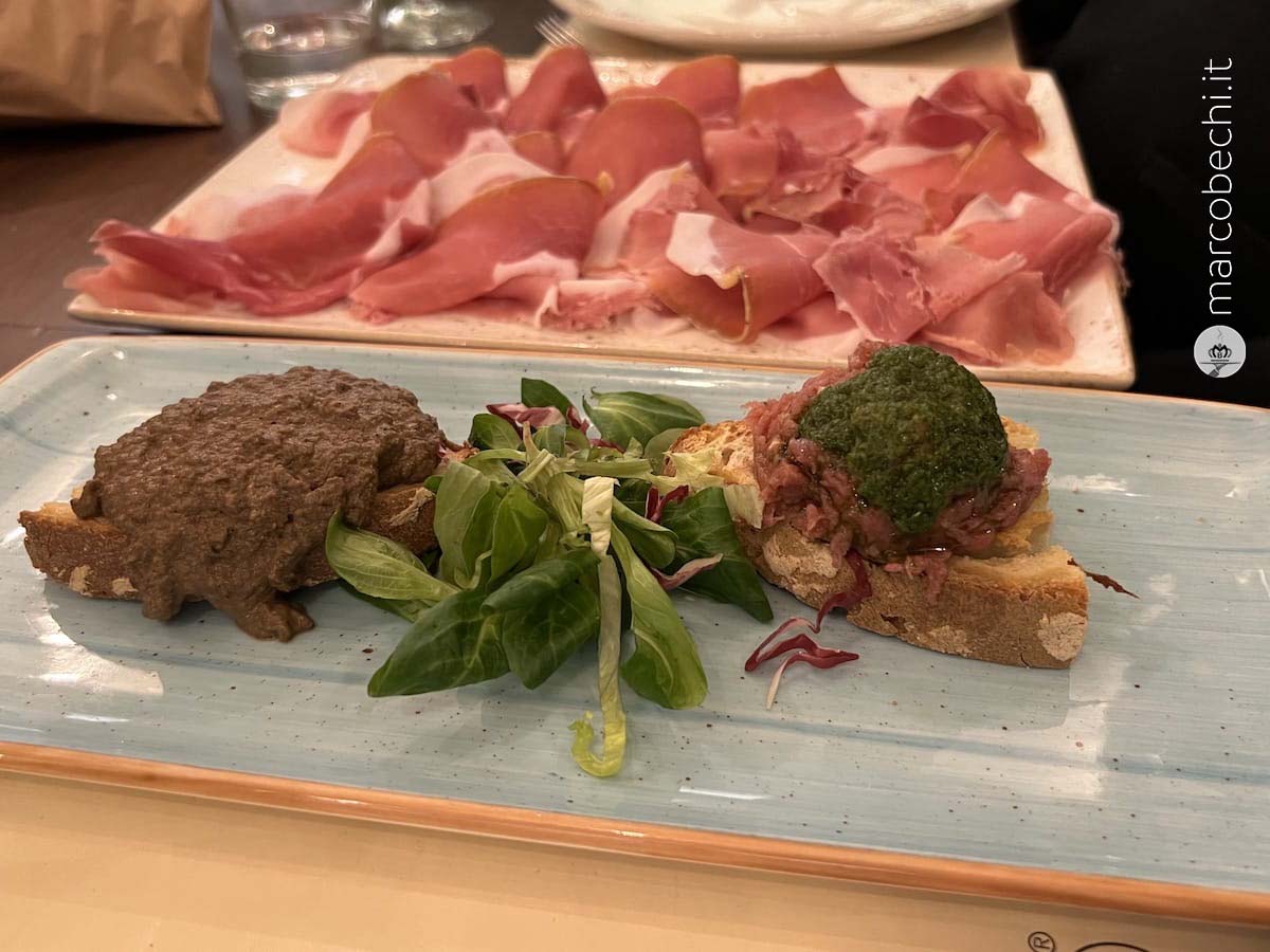 Prosciutto toscano, un crostino nero ed un crostino di tartare