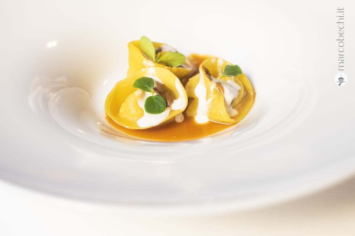 Tortelli ripieni di zucca al timo su riduzione di pollo con gamberi rossi di Mazara del Vallo marinati, caviale Asetra Imperial, croccante alla barbabietola e olio al dragoncello
