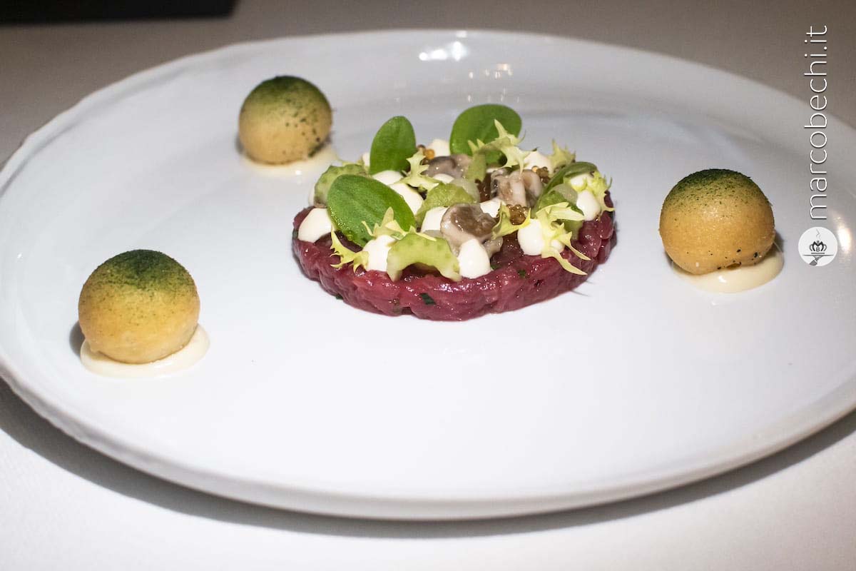 Battuta di manzo con ostrica scottata, sedano, vermouth, rafano e zeppole alle alghe